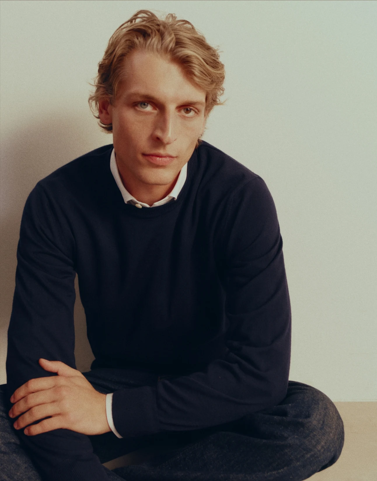modell in studio sitting down with merino sweater