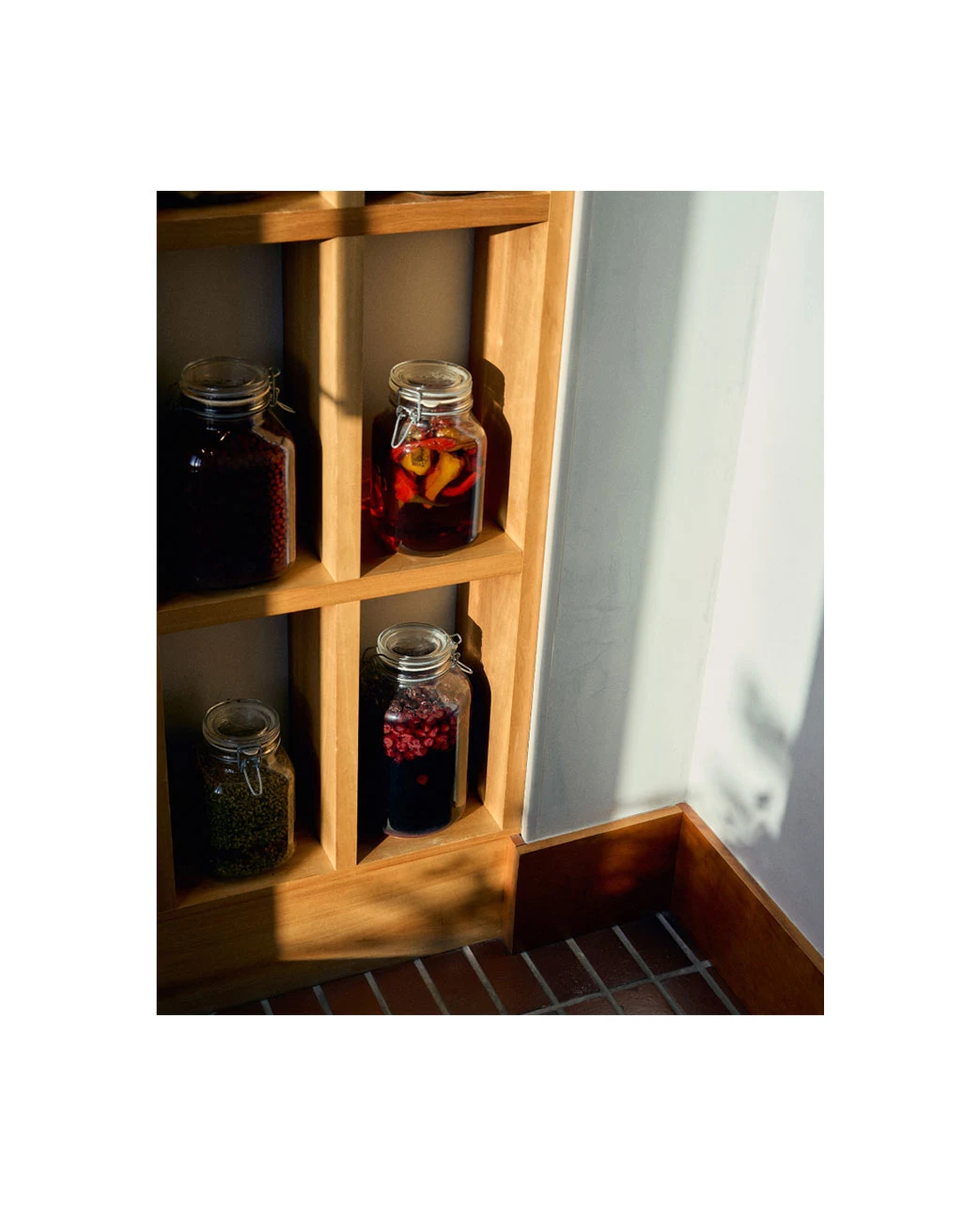 a shelf with pickled jars on two shelfs