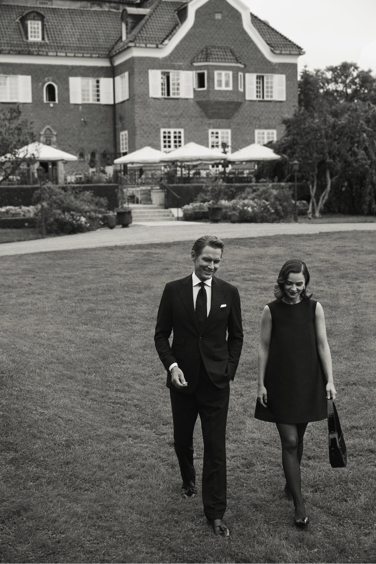couple evening dressed walking outside castle black and white image