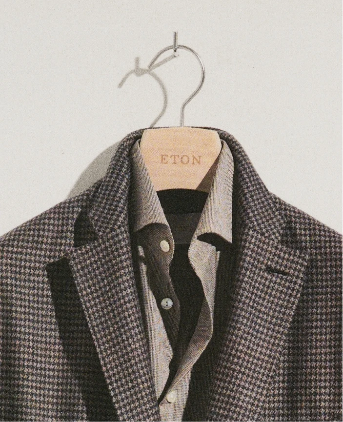 a close up of a hanger with a merino shirt and a soft jacket hanging on it