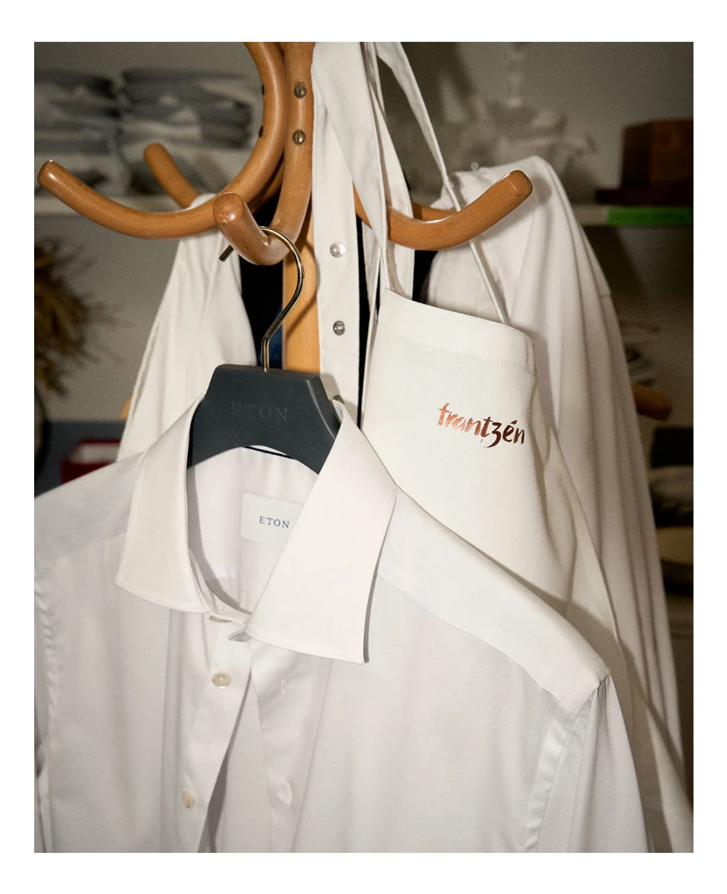 a white signature twill shirt hanging on a hanger with some apron