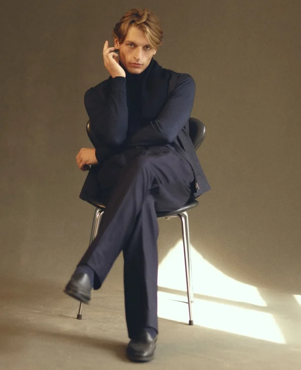 a man posing in a chair with a eton turtleneck sweater and soft jacket