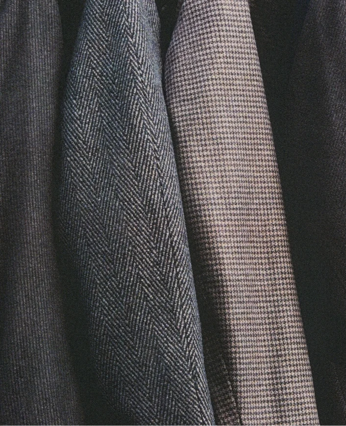 multiple outerwear pieces hanging next to each other with the sleeves in focus and in frame