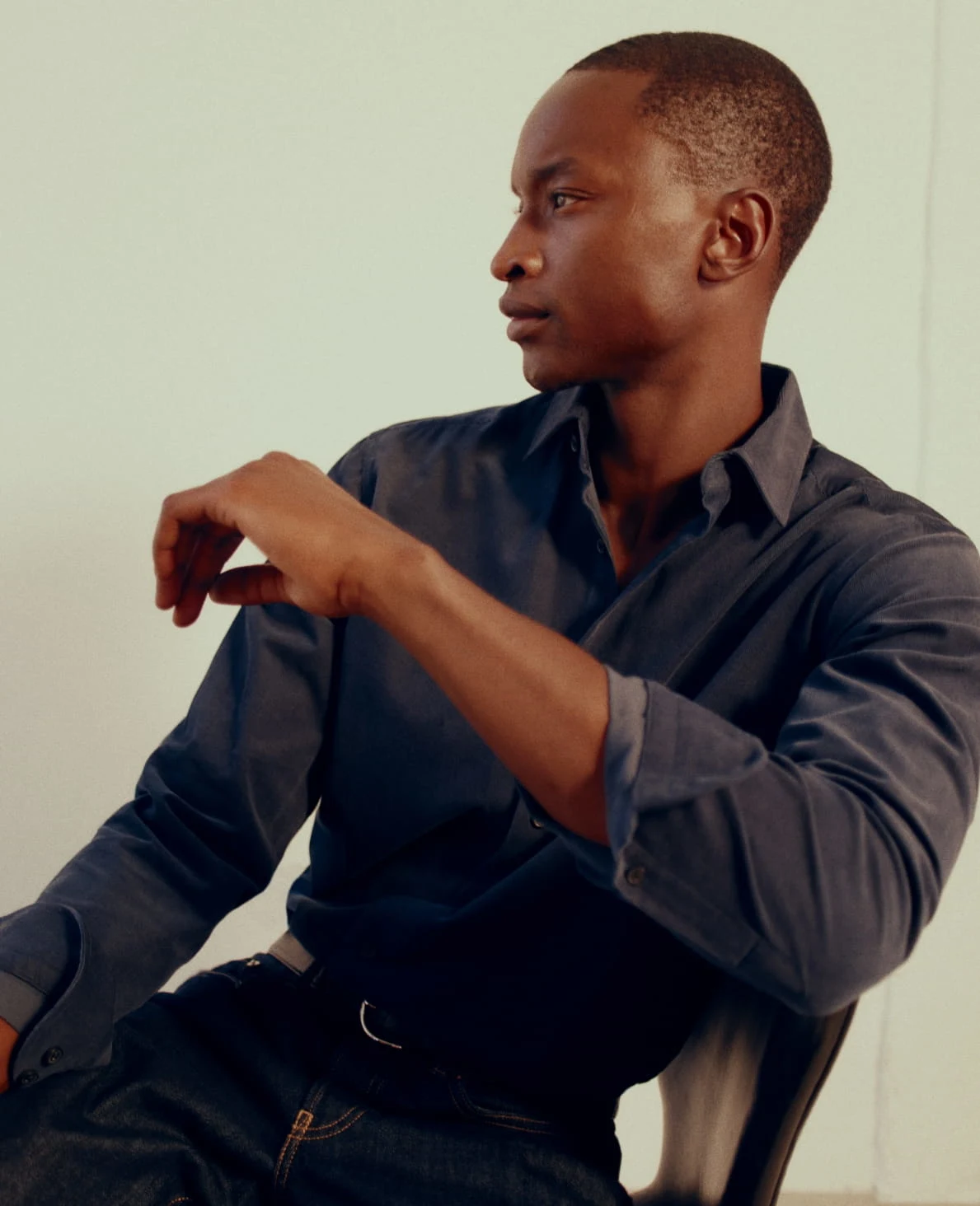 a model sitting in a chair posing in a corduroy shirt