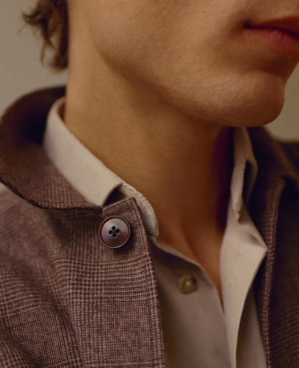 a close up shot of a model wearing a flannel shirt and flannel overshirt