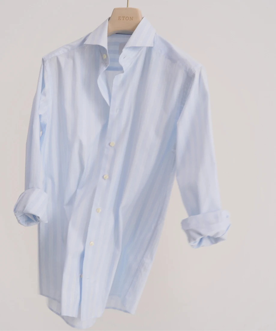 a hanging shirt with rolled up sleeves in a cream white backdrop
