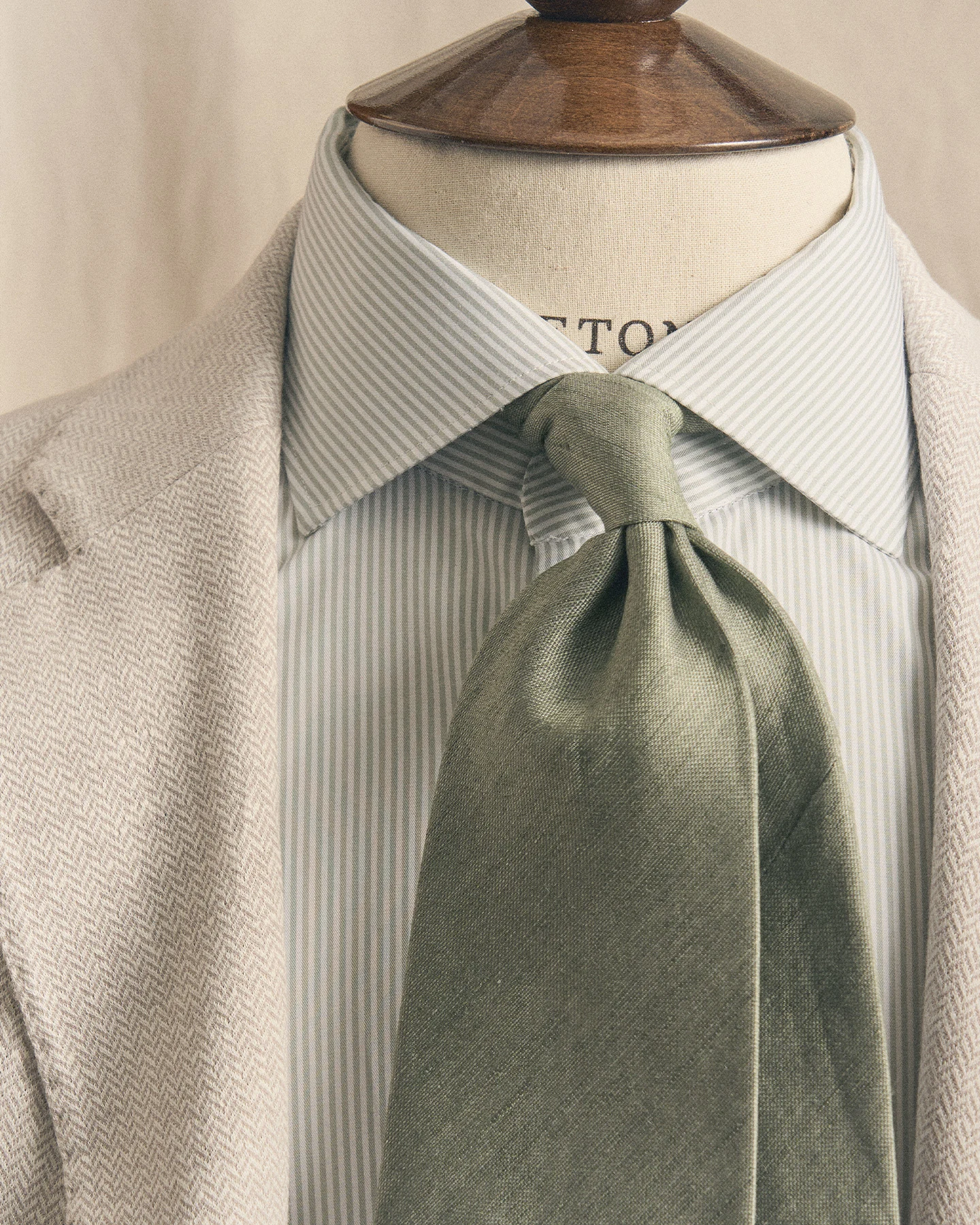 beige blazer with green tie