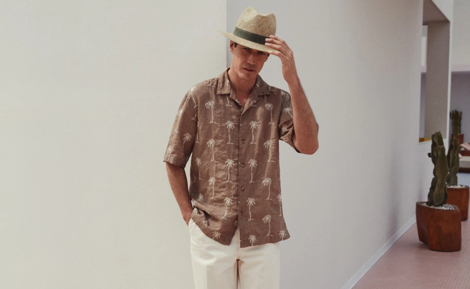 model in printed resort shirt and hat