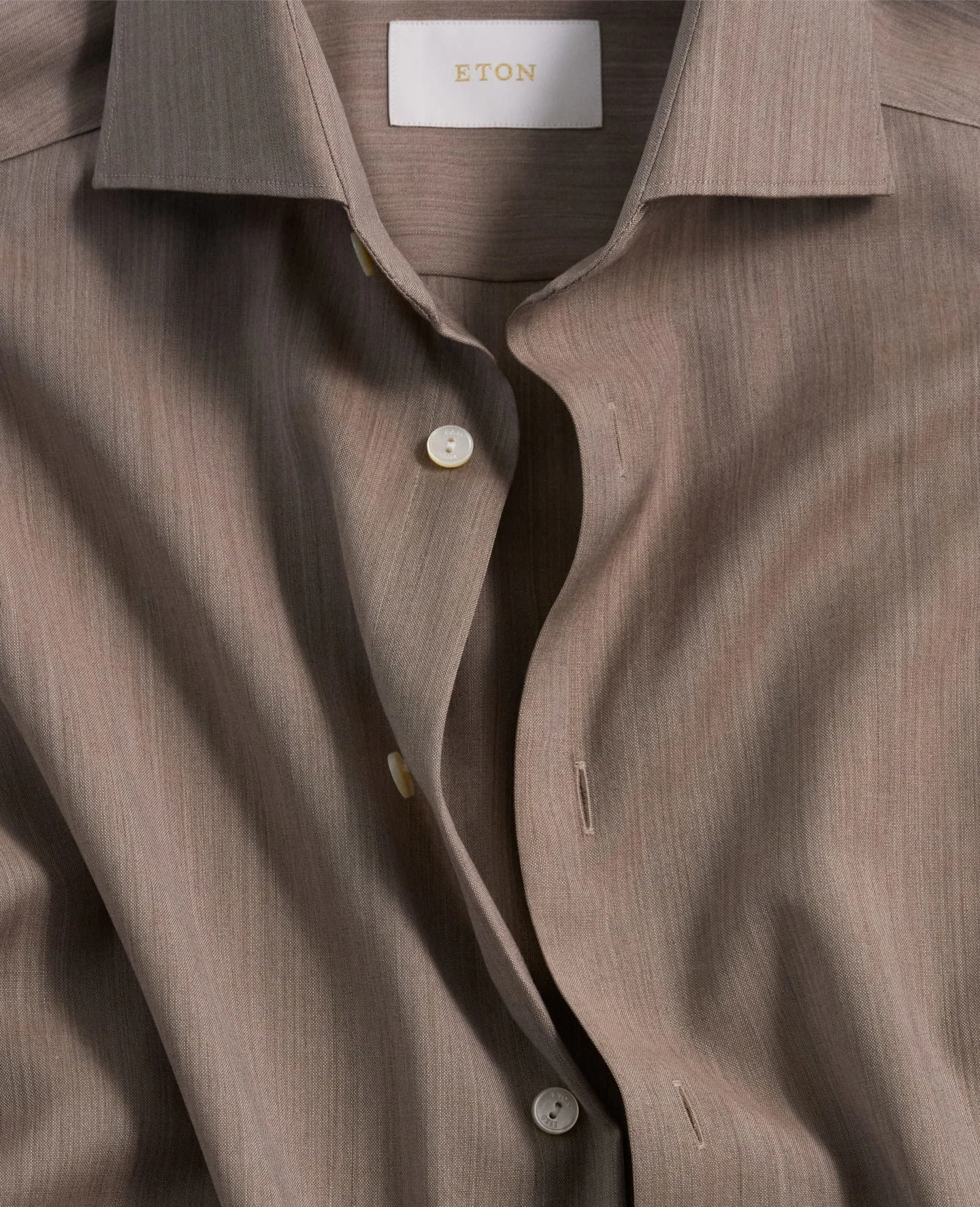 A close up of a light brown merino shirt