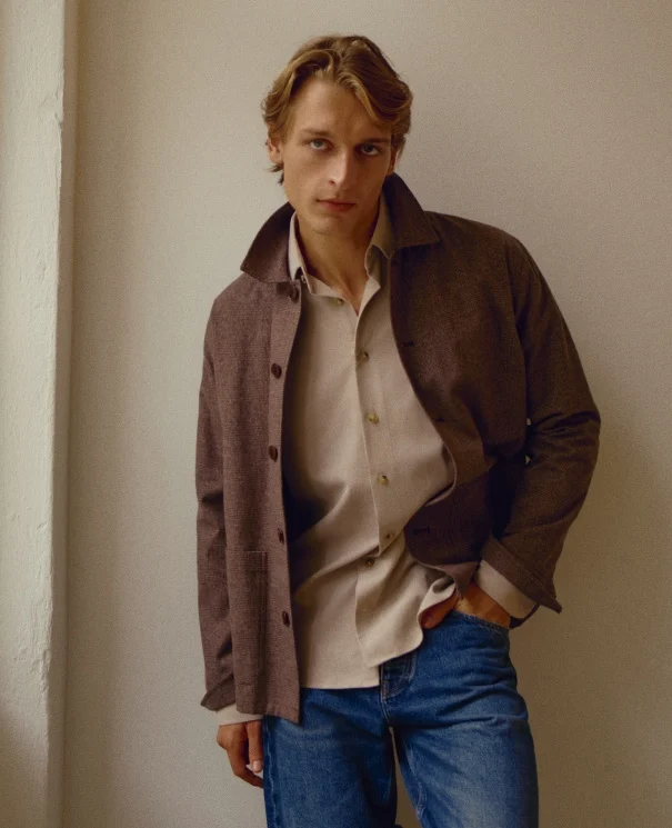 a model posing in a flannel shirt and flannel overshirt