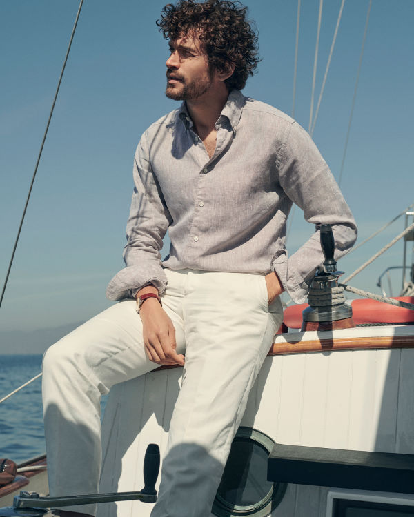 man on a boat in a beige linen shirt