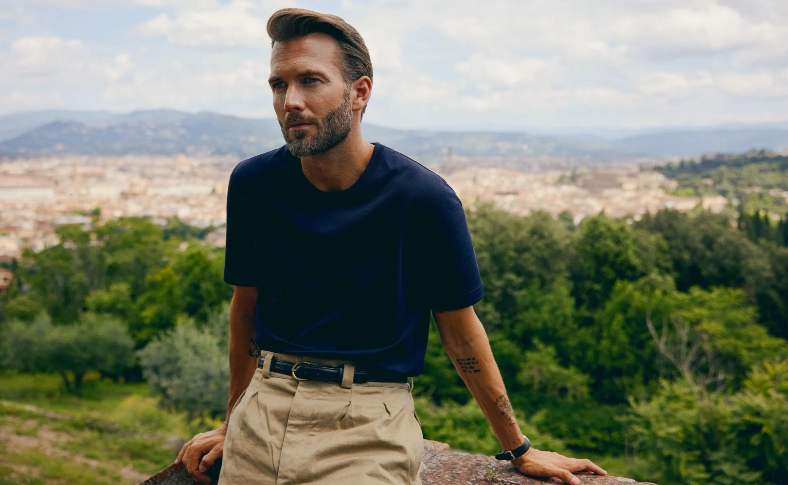 Eton dark blue t-shirt tucked in to a pair of light brown pants