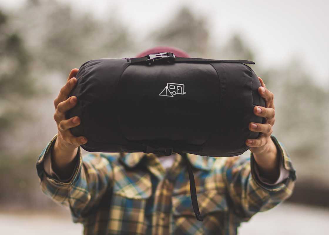 Person-holding-a-sleeping-bag