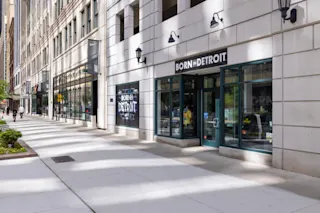 An exterior, street-level photo of the Born in Detroit storefront at The Lofts at Merchants Row.