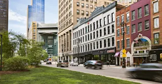 Street view of 630 Woodward and cars passing by. 