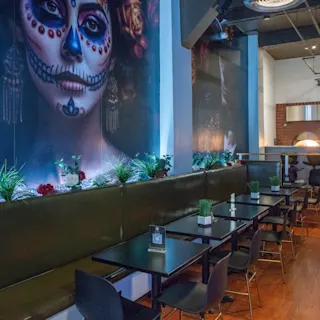 Interior photo of Pequeno Cantina in Detroit, featuring a wall mural and seating.