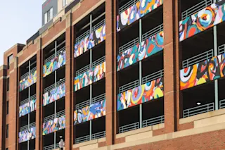 An exterior, close-up photo of the murals along the River Place Garage facade.