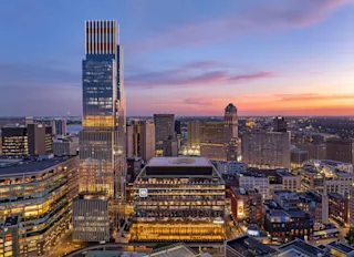 Aerial photo of Hudson’s Detroit, featuring the Block and Edition tower, at nighttime.