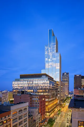 Aerial photo of Hudson’s Detroit, featuring the Block in the foreground and Edition tower in the background, taken at nighttime from a side angle.