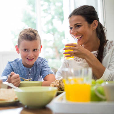 Mutter und Kind beim Mittagessen mit Fruchtsaft