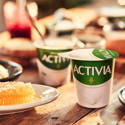 Zwei Activia-Joghurts auf einem rustikalen Tisch