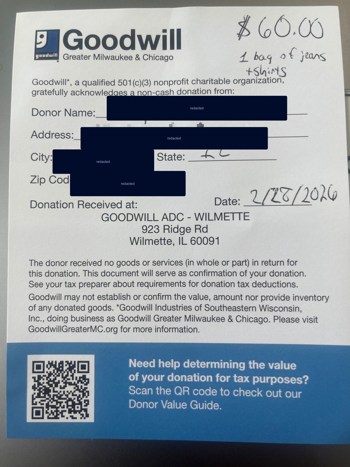 A real Goodwill donation receipt with the donor name and address redacted, showing a handwritten value of $60 for one bag of jeans and shirts