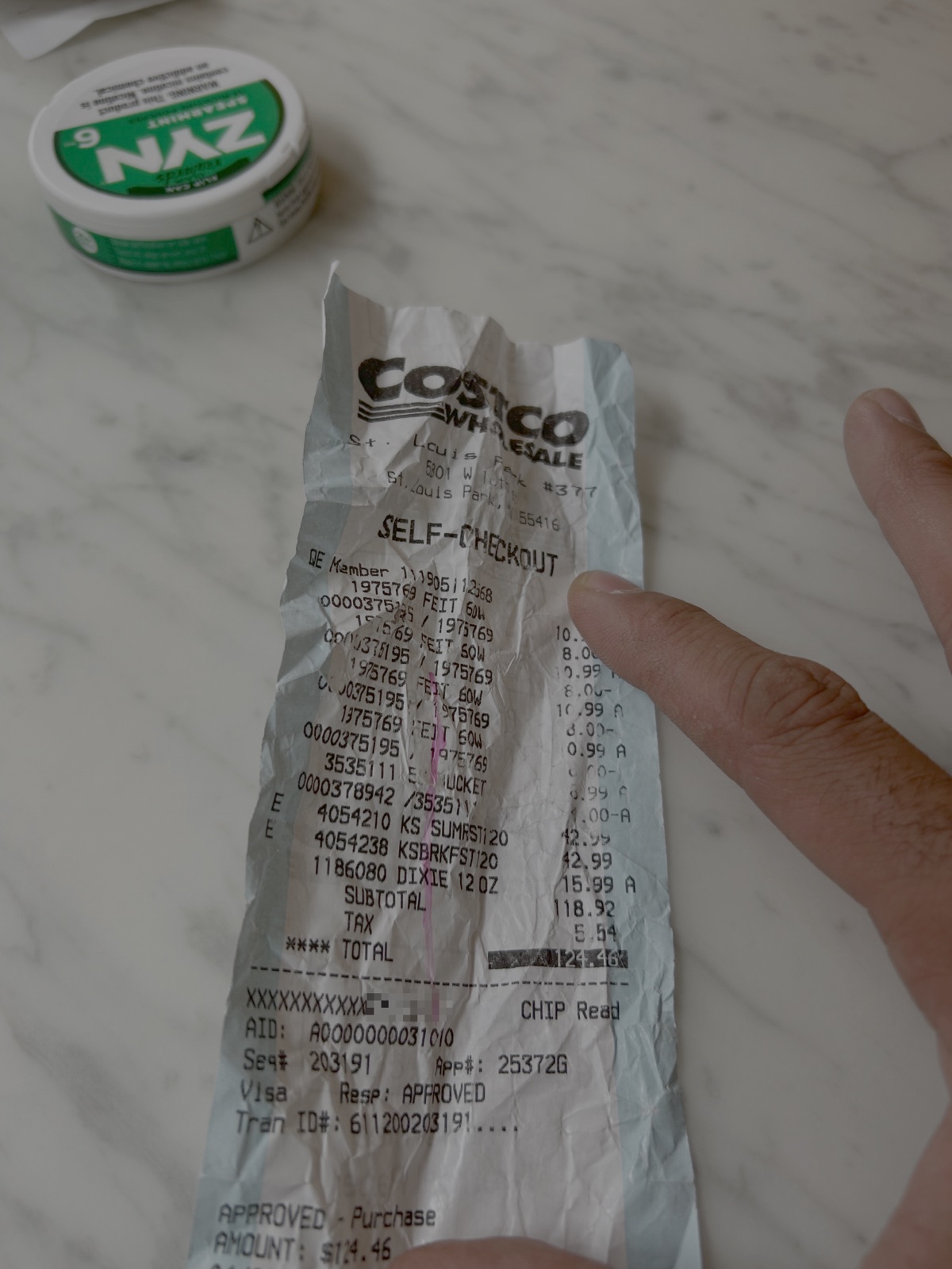 Real crumpled Costco self-checkout paper receipt with 15-plus line items totaling $124.46, scanned and anonymized for this article