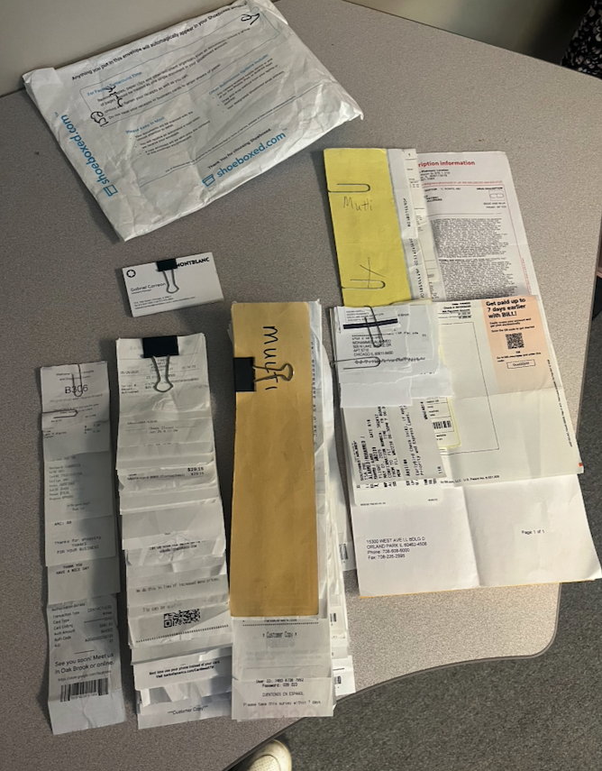 A real customer's receipts and Magic Envelopes spread out on a desk at Shoeboxed Durham headquarters, ready to be digitized