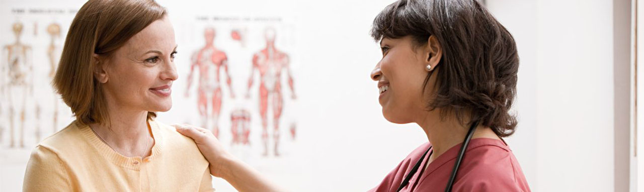 Une femme assise parle à un médecin