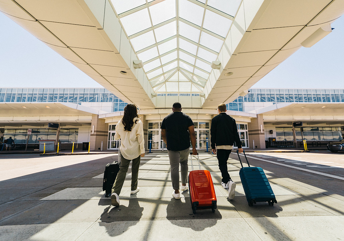 A photo of passengers walking across the crosswalk and into the Terminal of CVG Airport.