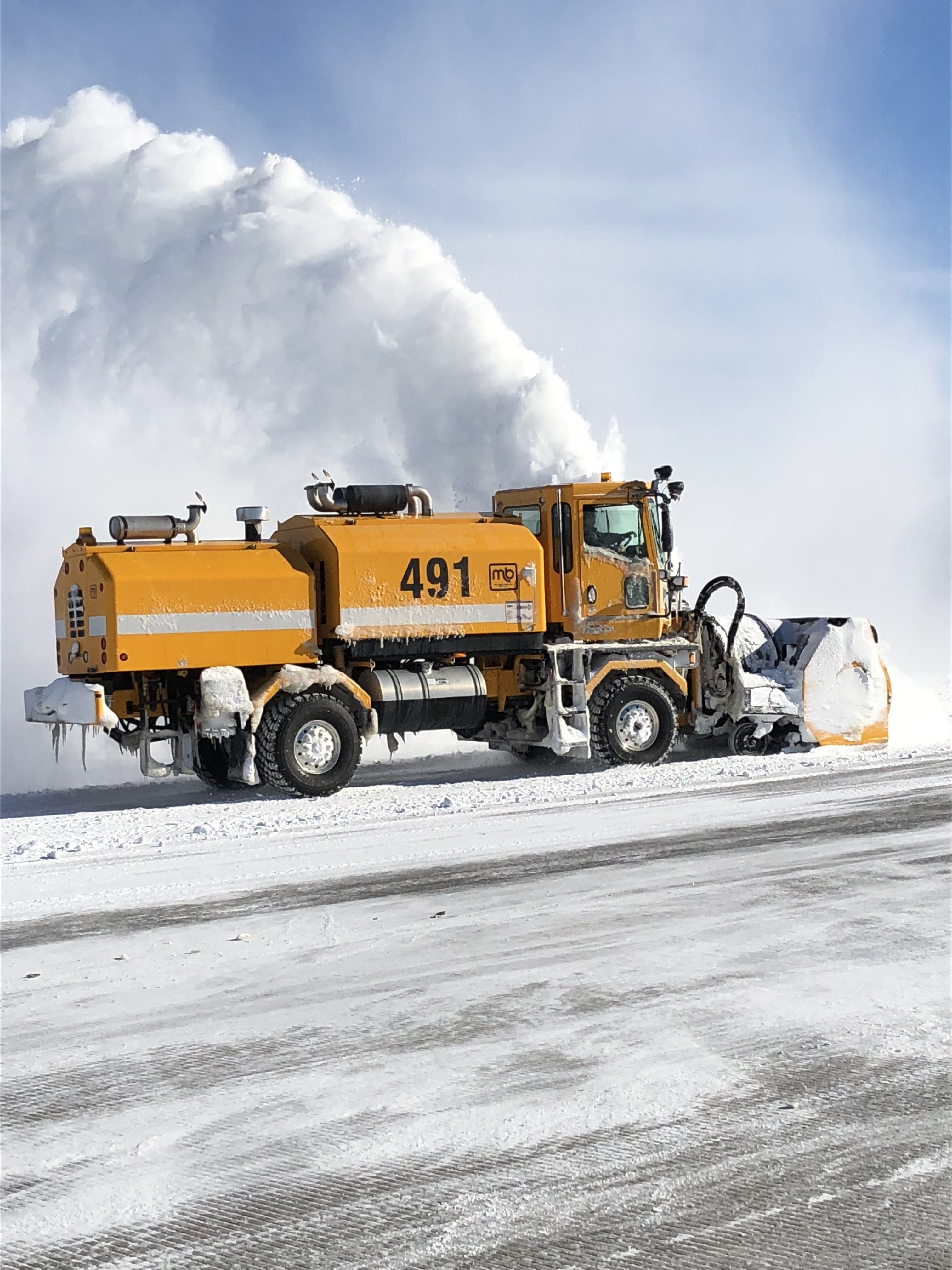 A photo of a winter operations truck plowing snow.