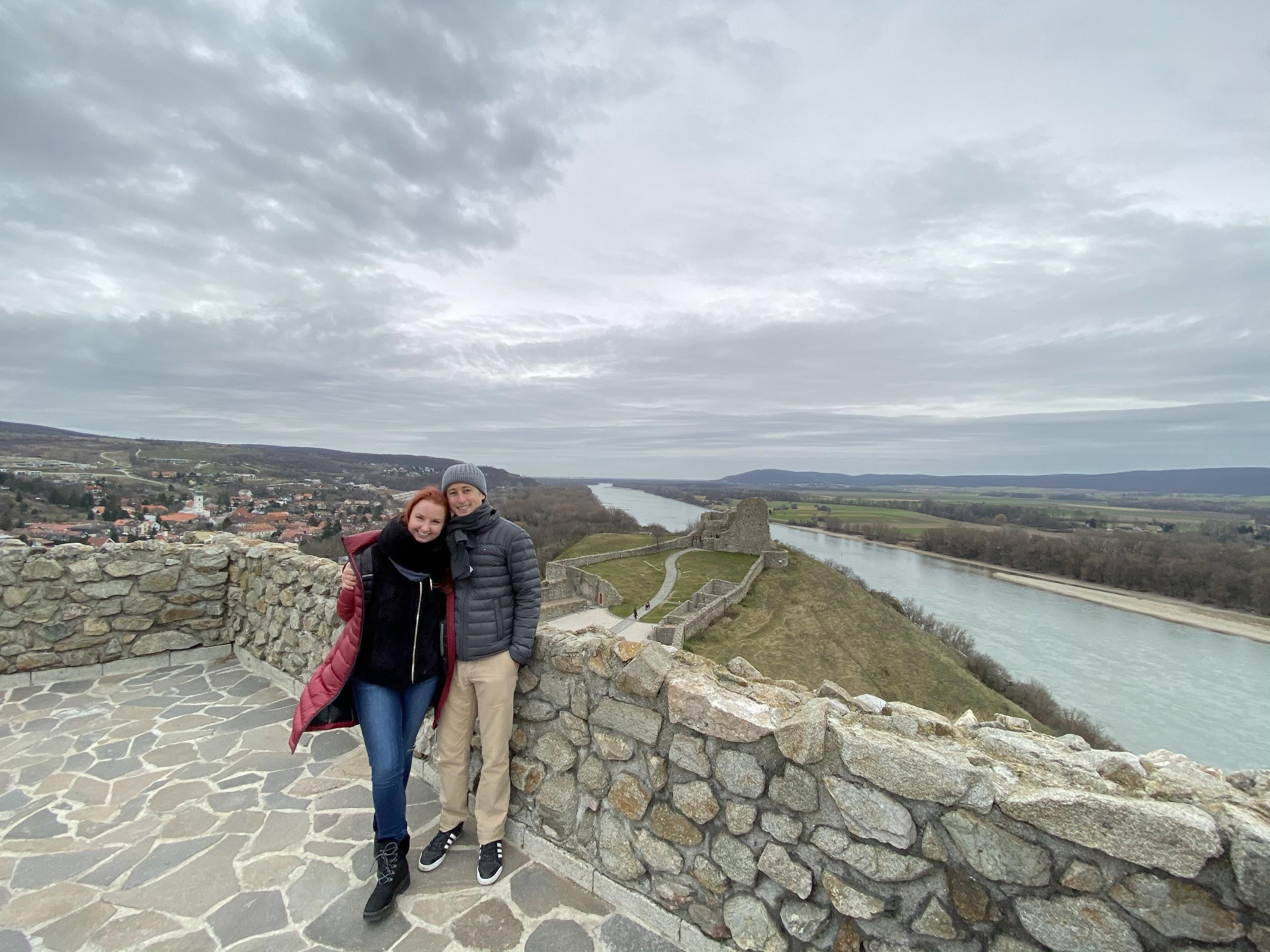 Jay and his wife in Bratislava, Slovakia in 2019 standing on an outlook above a river.