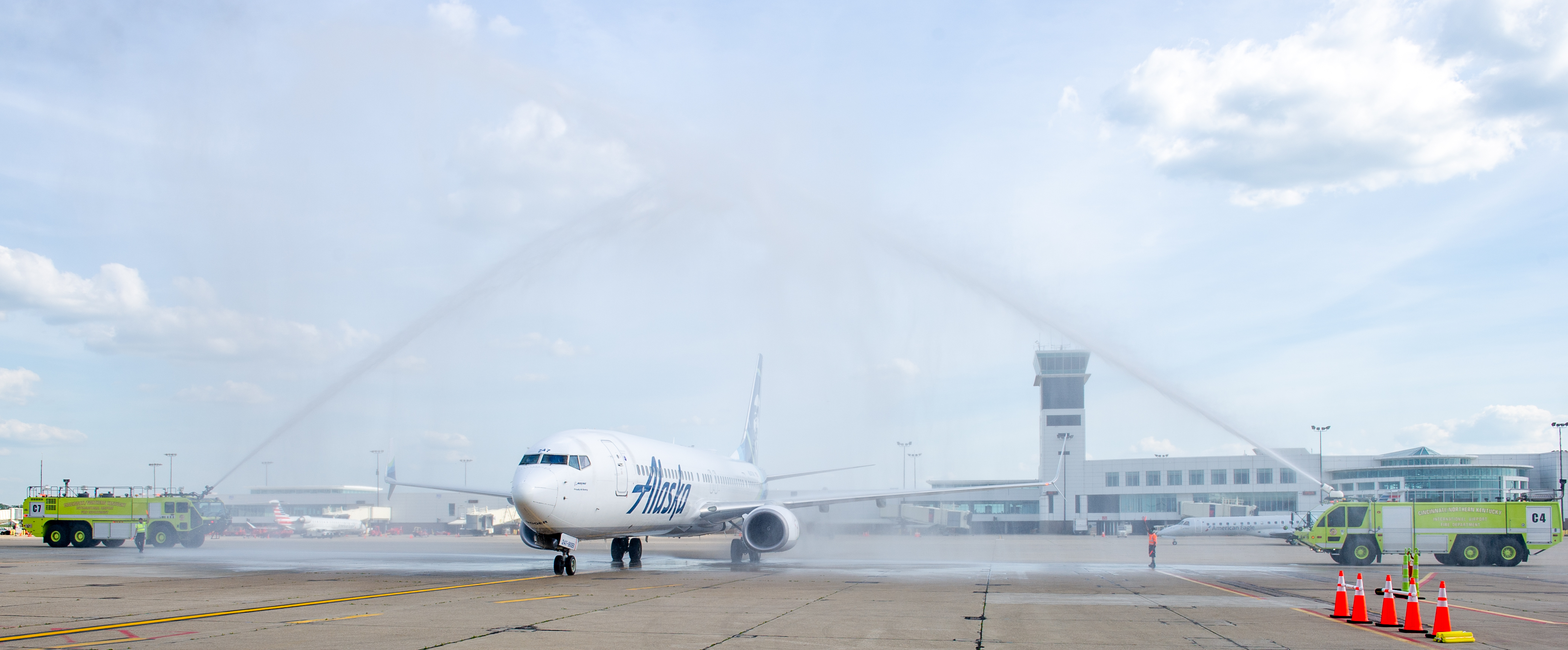 A photo of an Alaska Airlines plane taxiing under a water cannon salute.