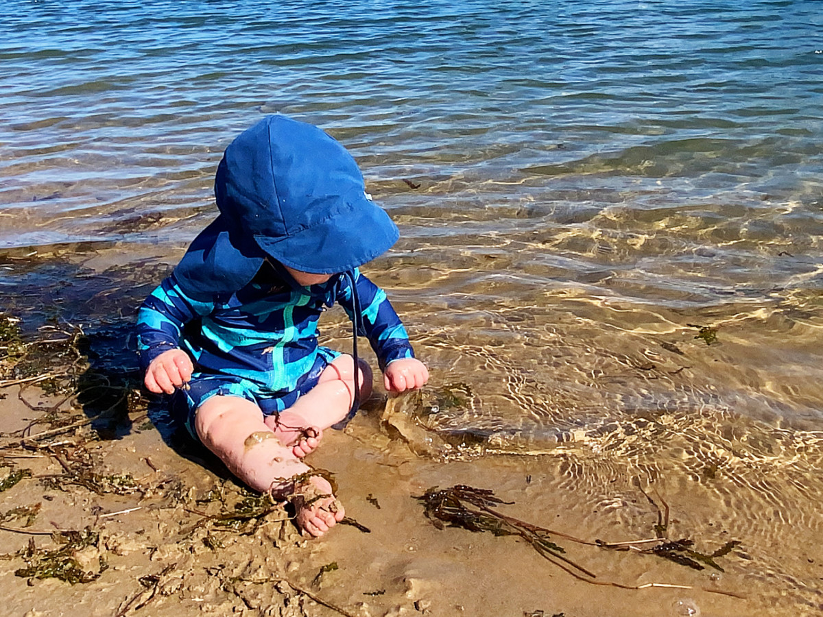 A photo of a baby at the beach.