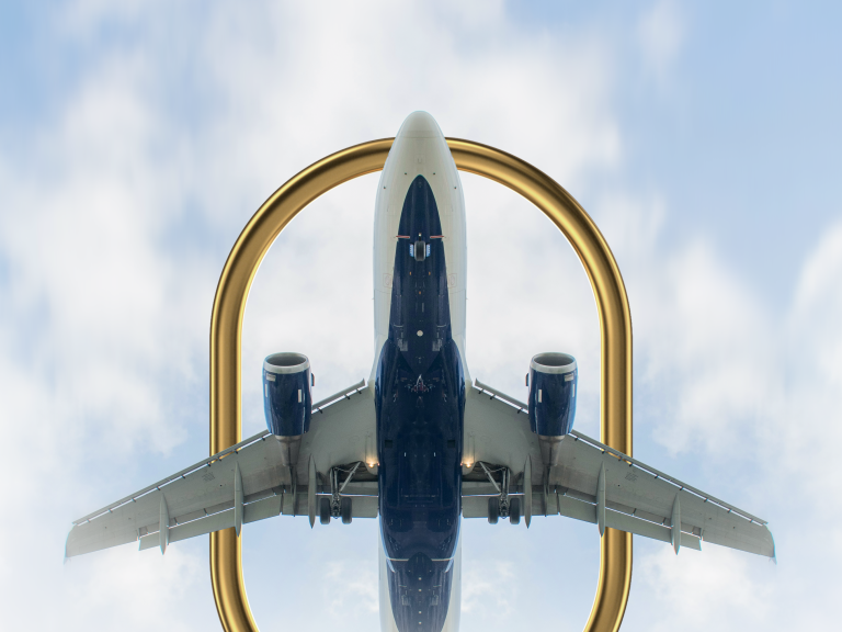 A photo of an airplane flying through a golden ring in the sky.