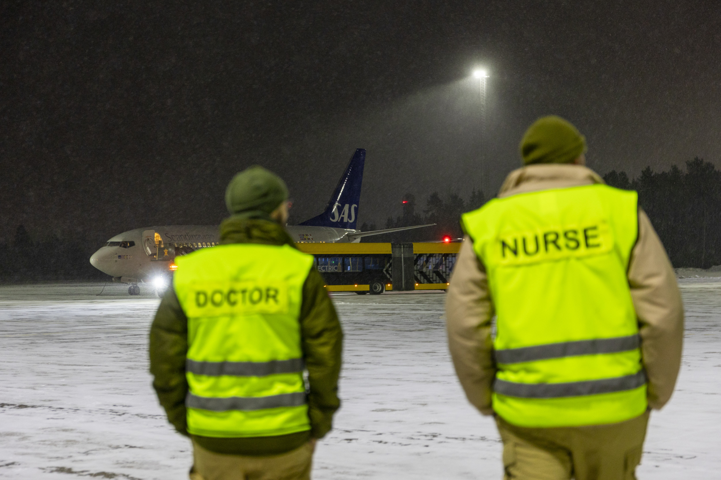 En läkare och en sjuksköterska går mot ett SAS MEDEVAC-flyg innan ett uppdrag för att hämta patienter och anhöriga från Ukraina, för vidare transport till sjukhus i Europa. Foto: Frederik Ringnes / Forsvaret