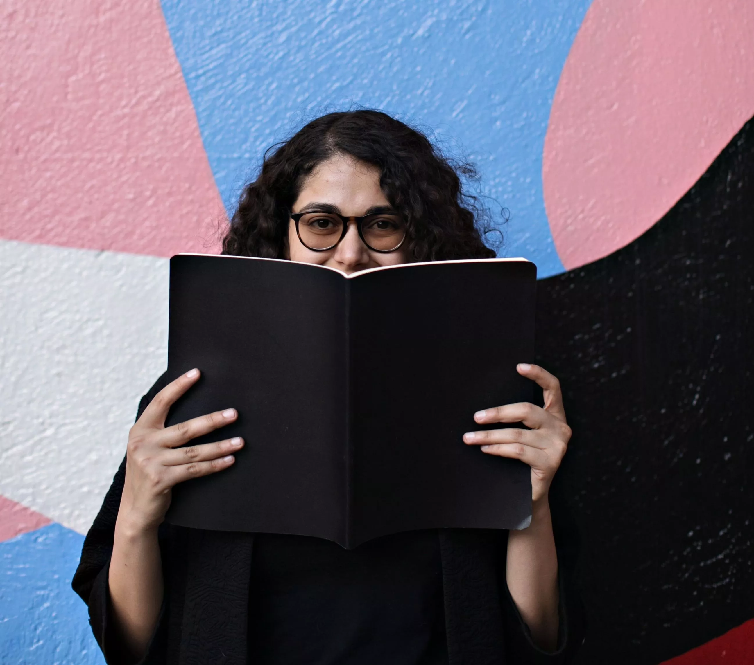 teacher smiling behind a book