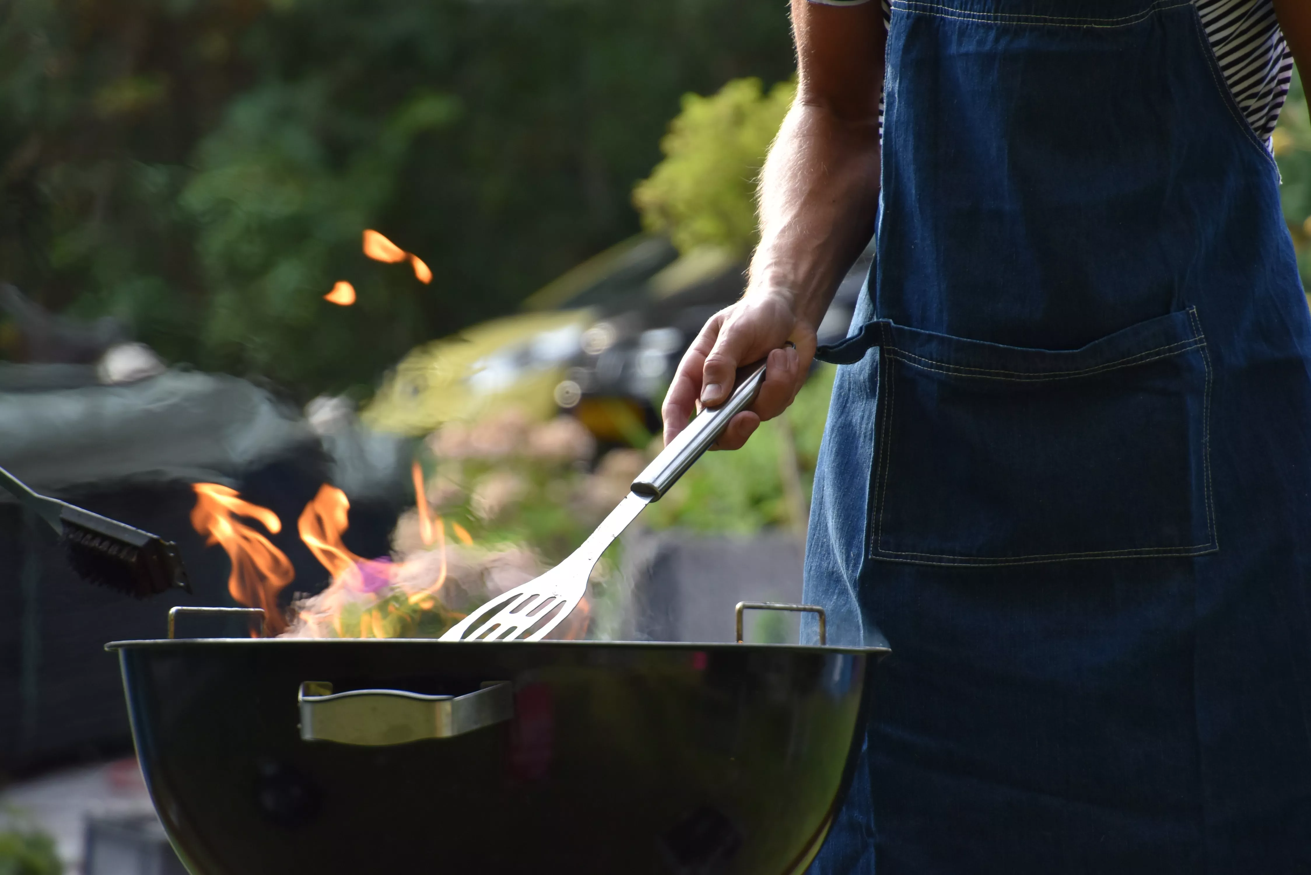 man flipping burgers on a grill