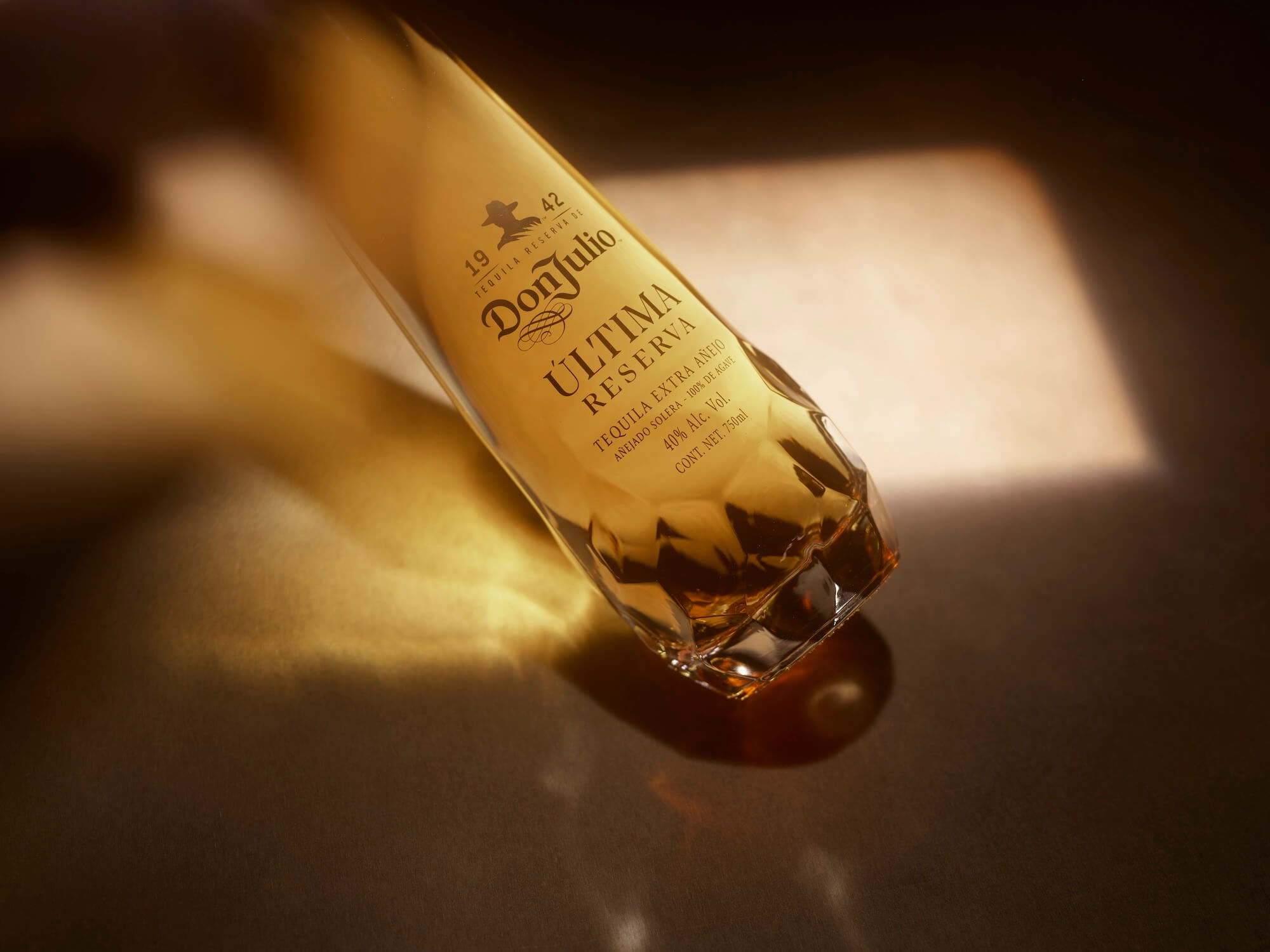 A close-up of a Don Julio Ultima Reserva Tequila bottle lying on its side