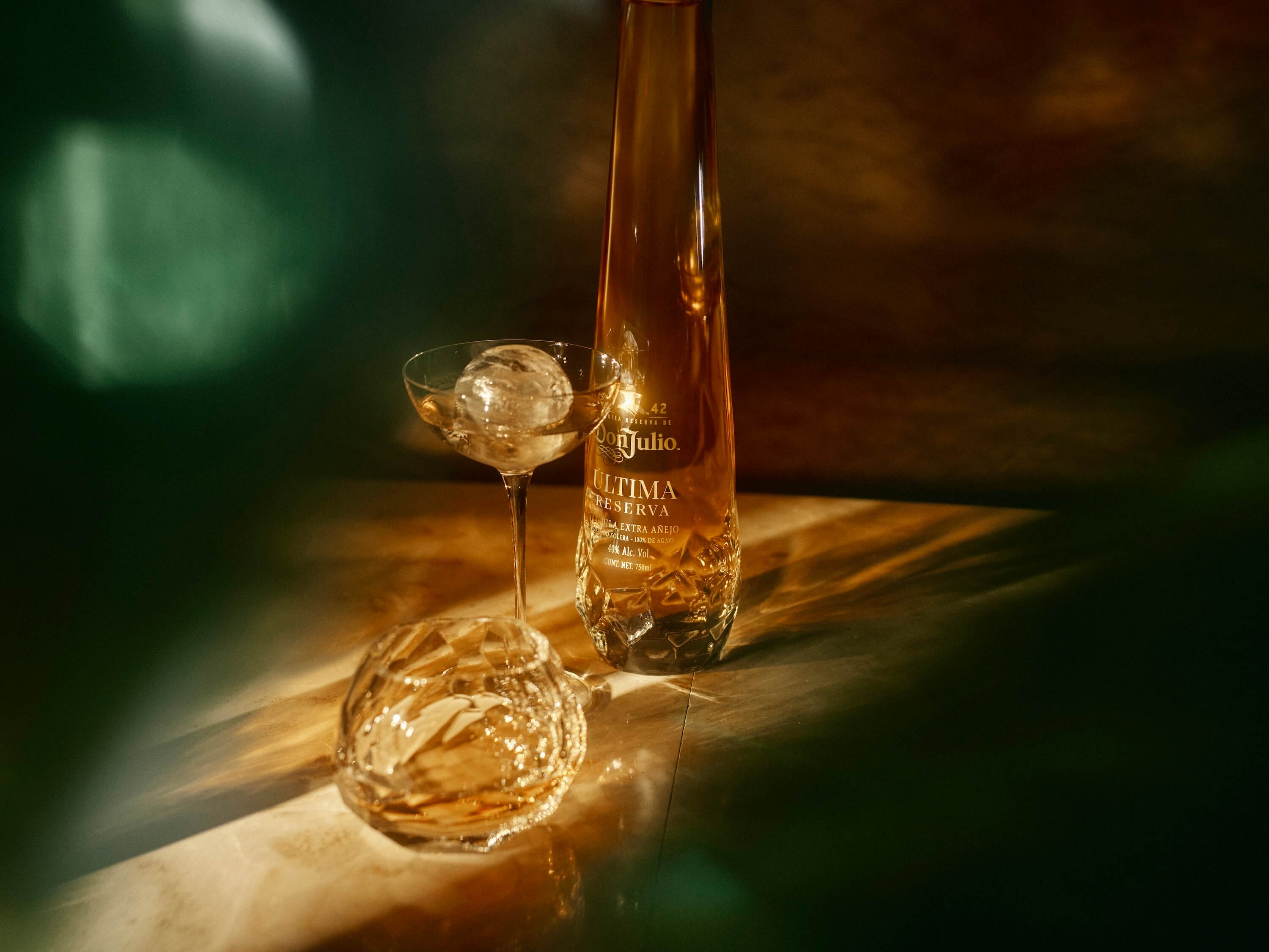 A bottle of Don Julio Ultima Reserva tequila displayed in a warm, atmospheric setting.