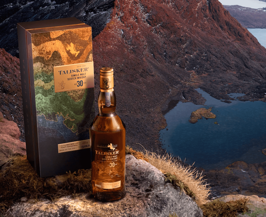 The image shows a bottle of Talisker 30-Year-Old Single Malt Scotch Whisky placed on a rocky surface