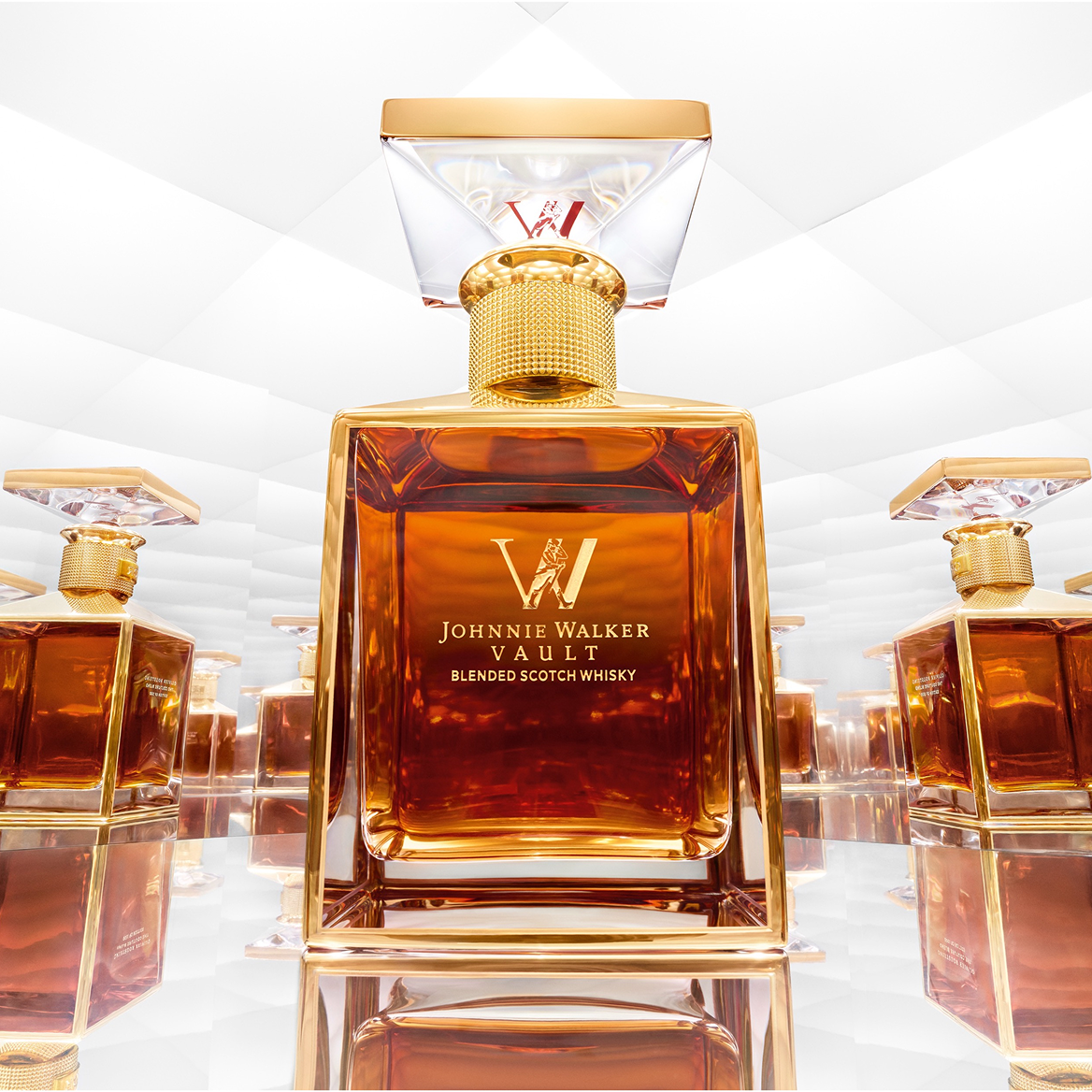 Johnnie Walker Couture Blend with a gold cap, elegantly displayed on a mirrored surface, highlighting its premium look.