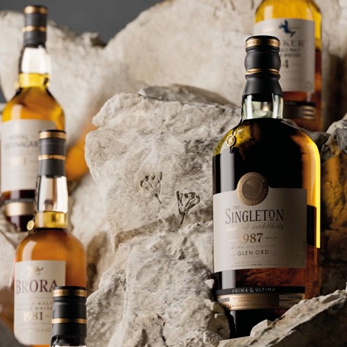 A bottle of The Singleton of Glen Ord 1987 Prima & Ultima single malt scotch whisky elegantly sits on a bed of textured stone 