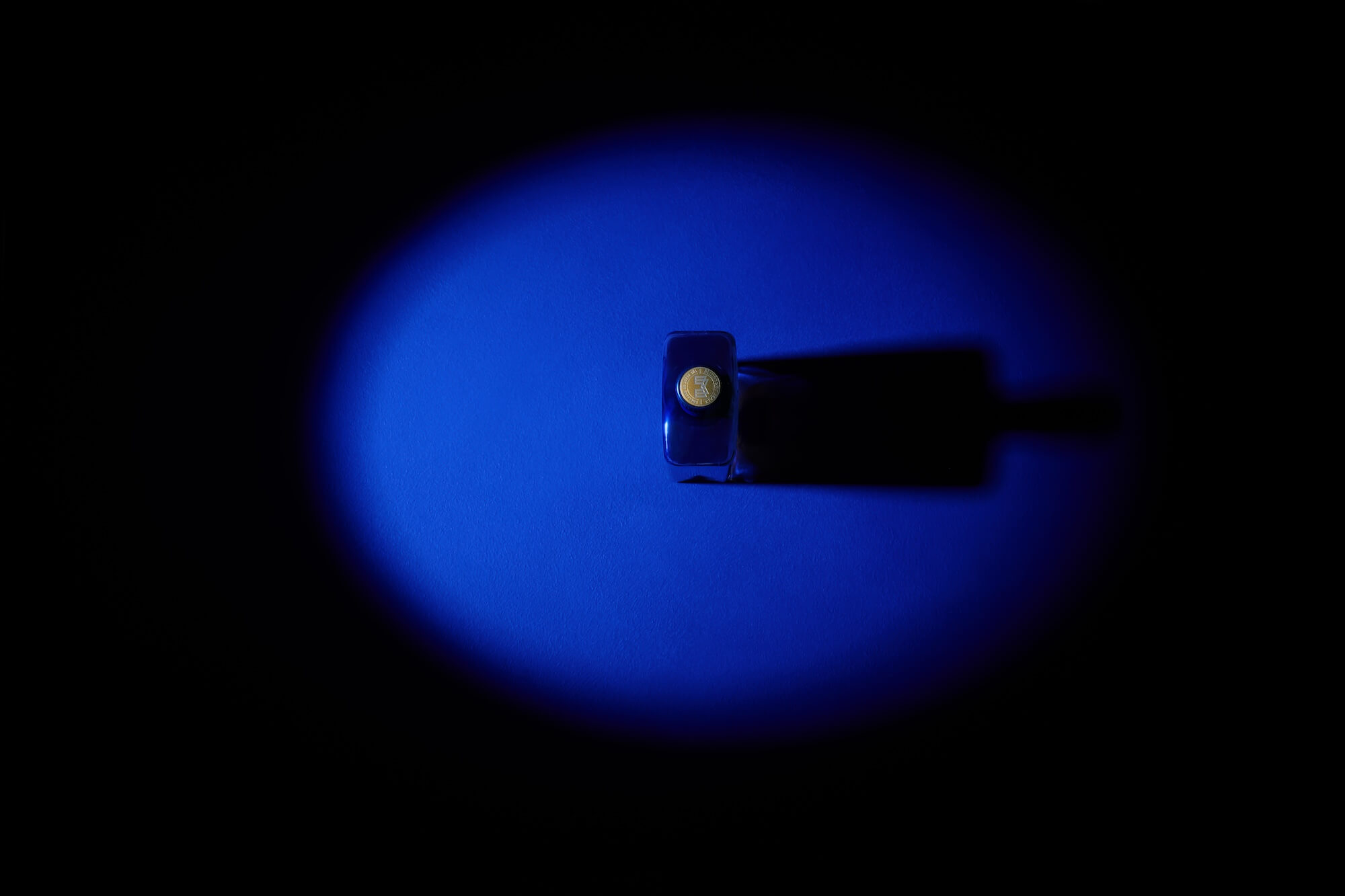A blue light casts a glow on the top of a Mortlach 30-year-old bottle, captured from a top-down perspective