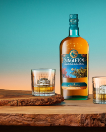 A bottle of The Singleton 14-Year-Old Single Malt Scotch Whisky is elegantly displayed on a rustic wooden surface