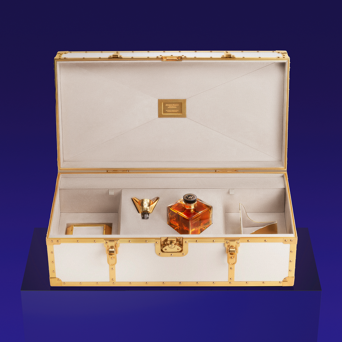 Luxurious white case with gold accents showcasing a Johnnie Walker Couture Expression bottle and accessories on a deep blue background.