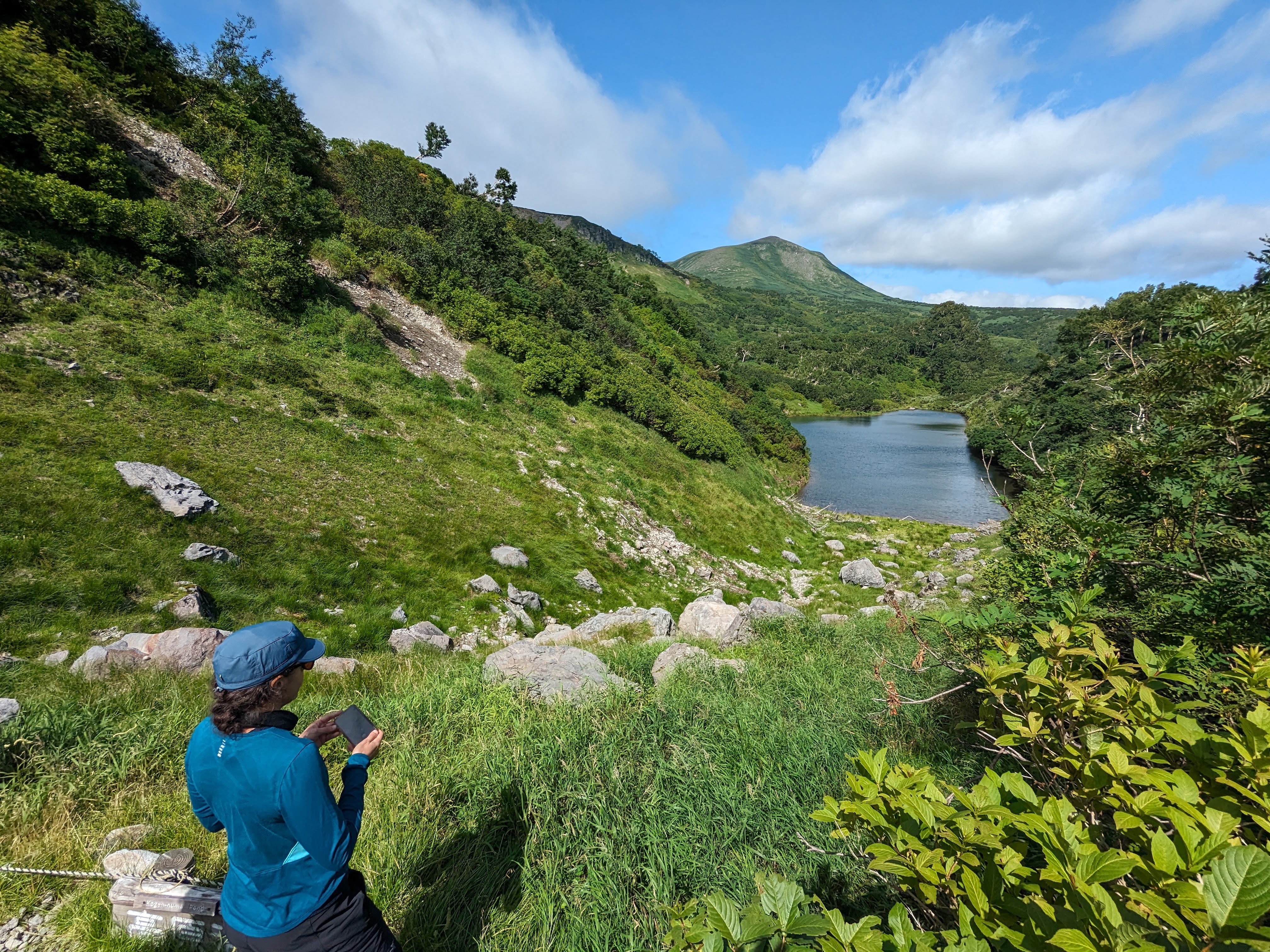 A hiker admires the view of a pond at Kogen Numa.