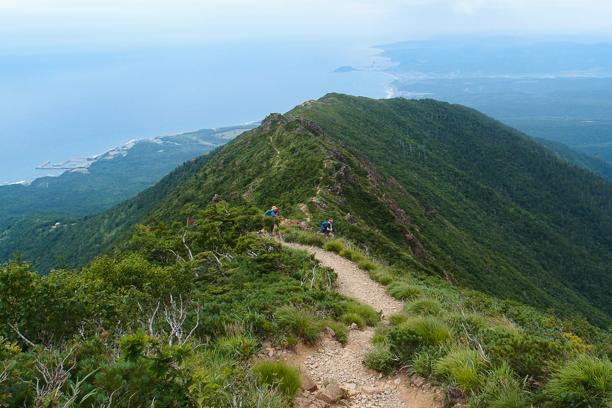 Hikers above the Pacific Ocean on the Mt Apoidake hiking trail in Hokkaido