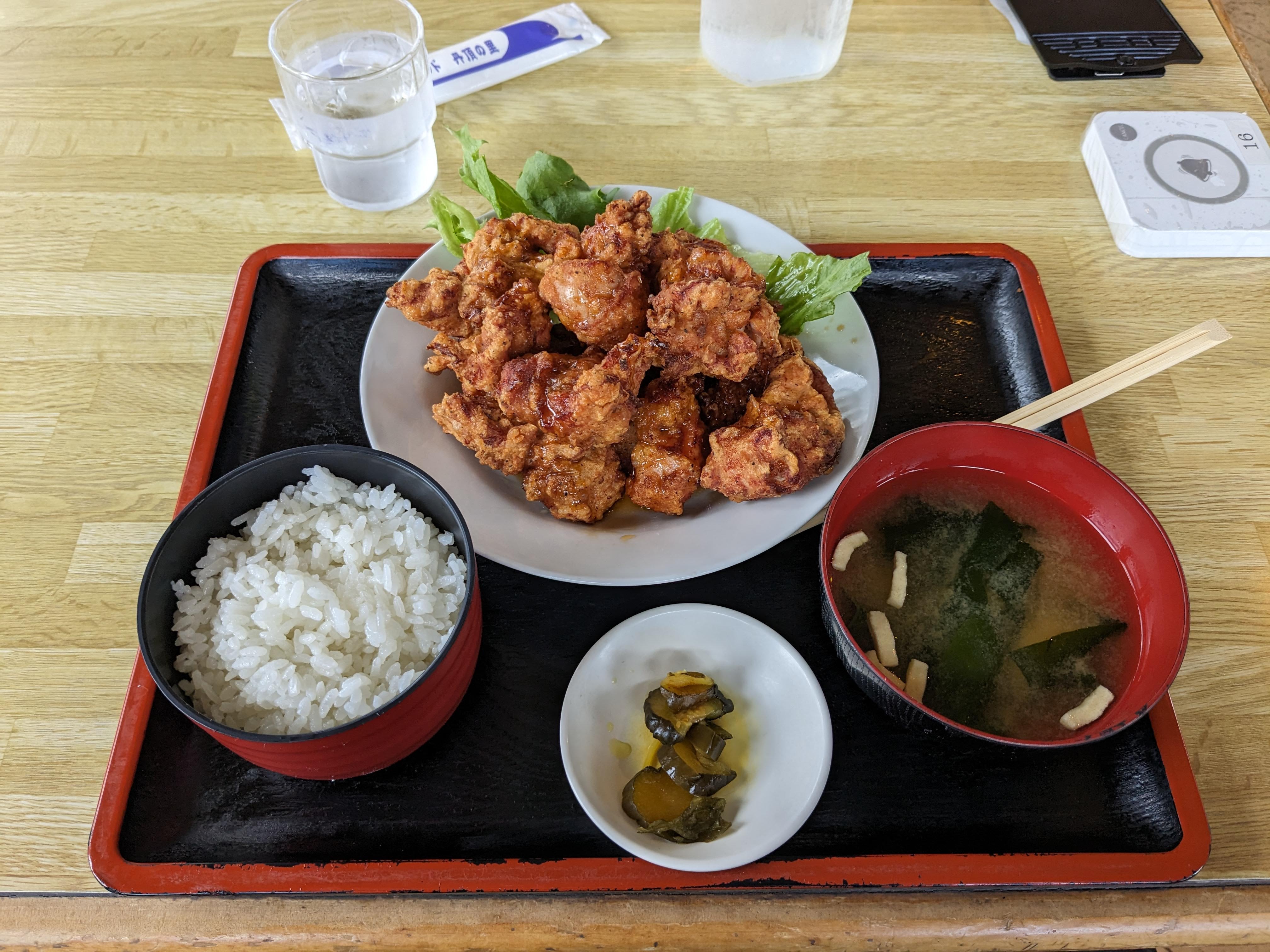 A plate of Hokkaido speciality fried chicken sits on a tray with a bowl of rice, a bowl of pickles and miso soup.