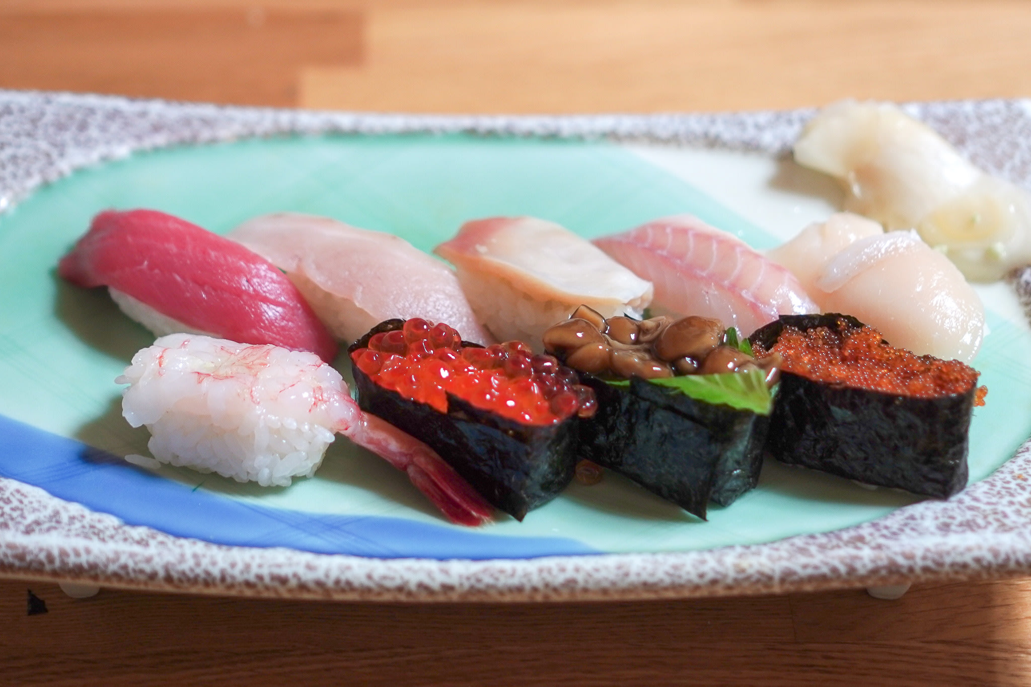 A plate of ten pieces of nigiri sushi (small balls of rice with raw fish on top).